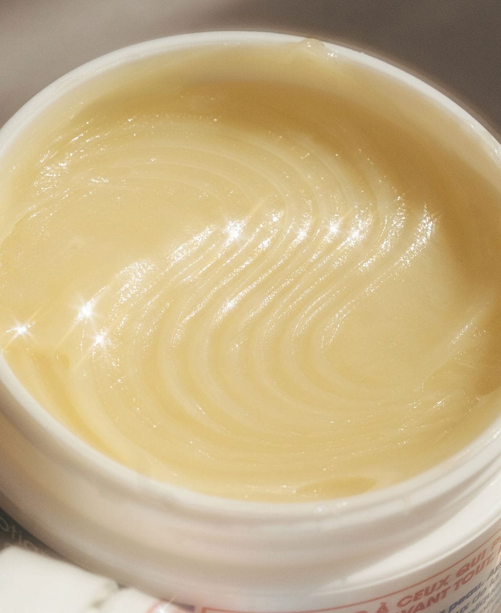 Close-up of the swirled golden balm inside an open jar